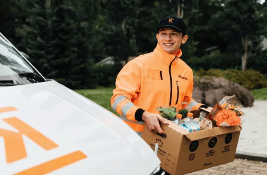 A person carrying a box with groceries in it.