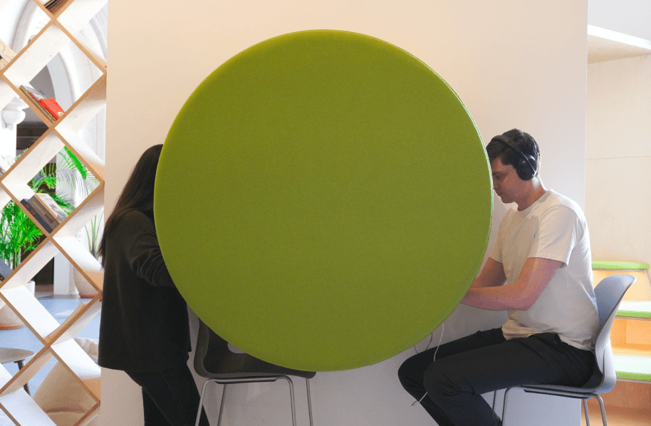 Two people sitting at a table, obscured by a big green circle.