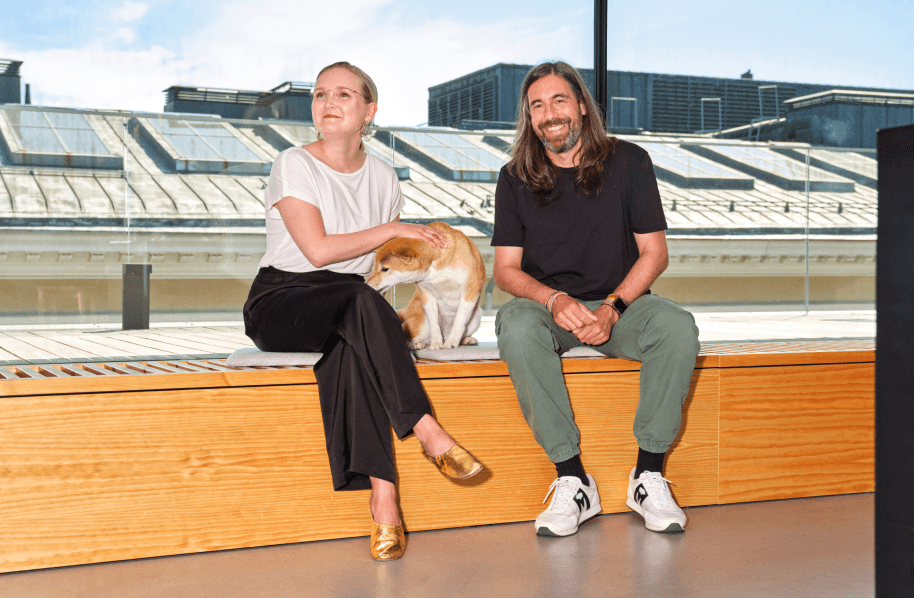 Two people sitting with a dog.